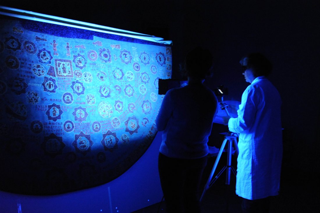 Ursula Drewello und Sibylle Ruß untersuchen den Sternenmantel im UV-Licht.
