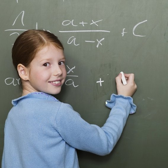 [Translate to English:] Ein Schulmädchen schreibt komplizierte Formeln an eine Tafel.